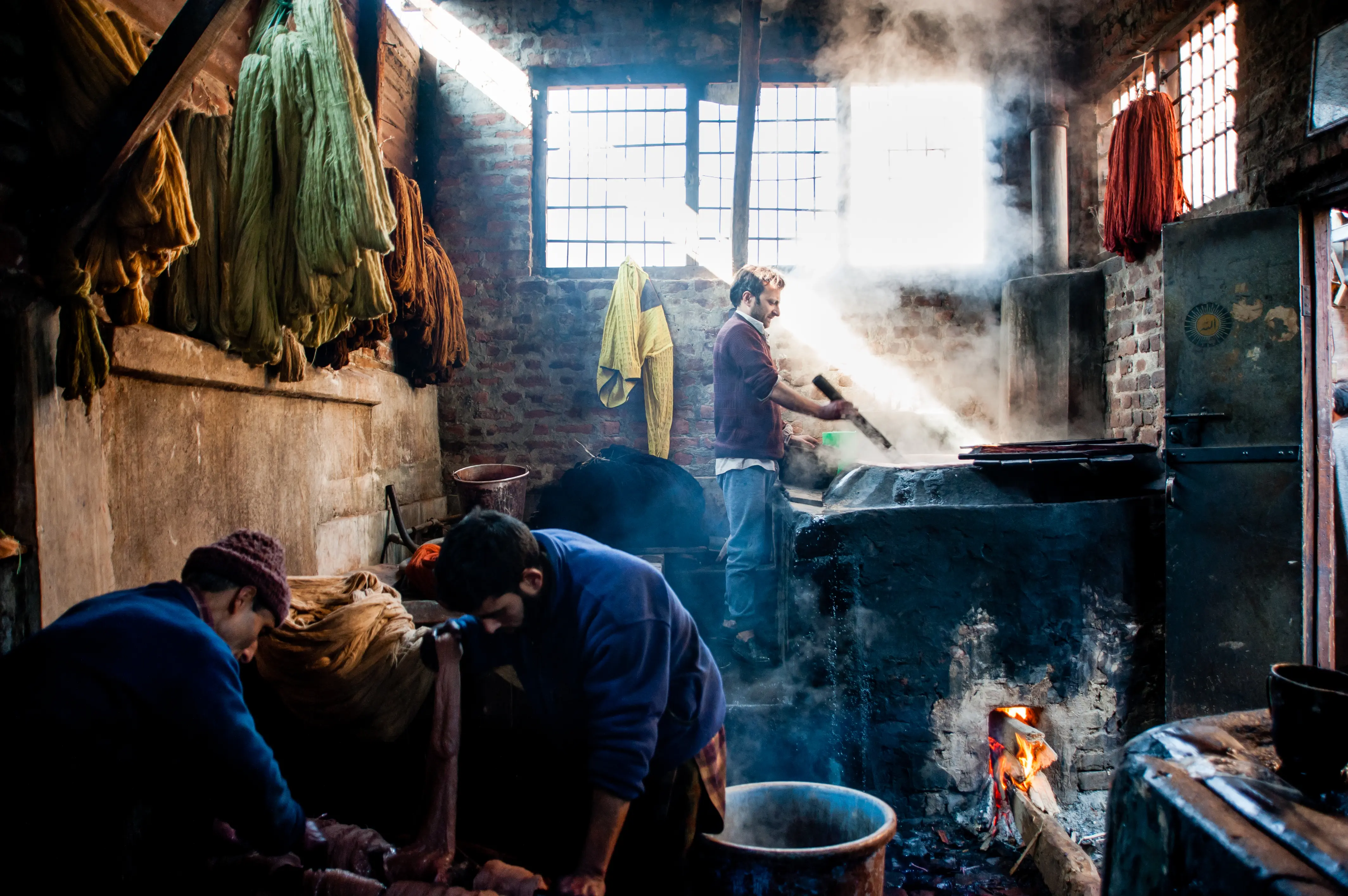 Artisans working in a dye workshop, steam rising from the vats