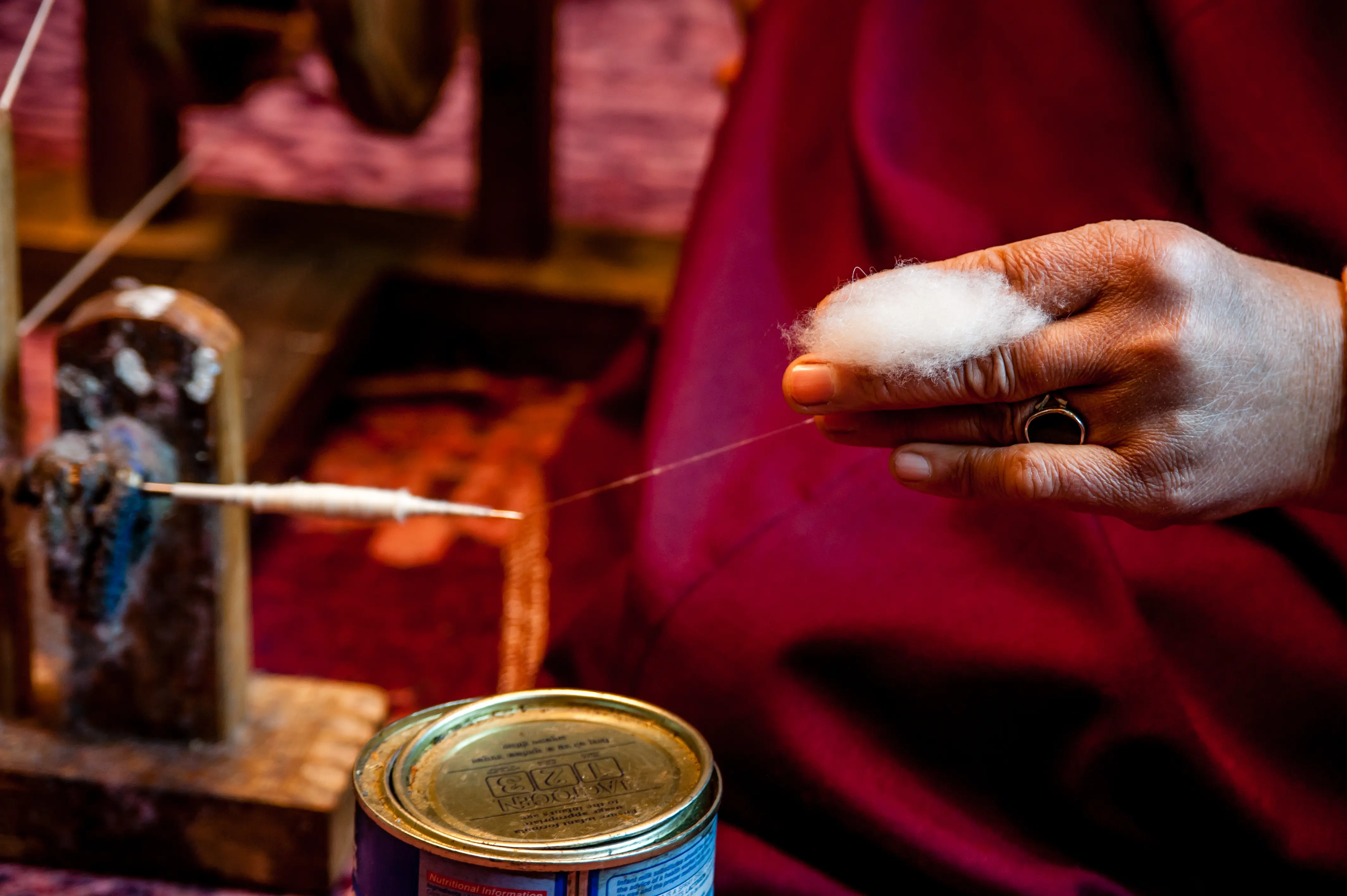 An artisan hand-spinning pashmina fibre onto a traditional spindle
